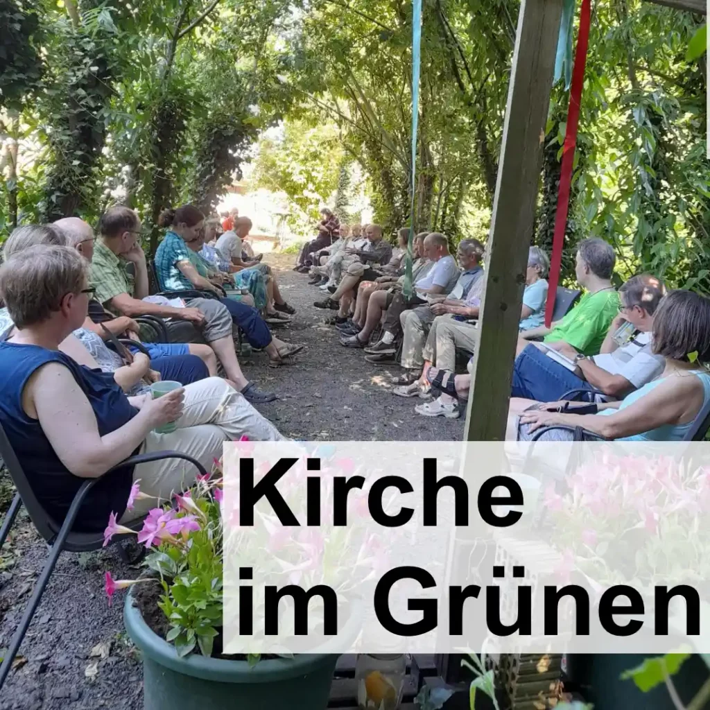 Unter dem Blätterdach der schattigen Weidenkapelle geschützt vor der Hitze, sitzen über 20 Menschen. Im Vordergrund ist ein großes Holzkreuz. Text: "Kirche im Grünen".